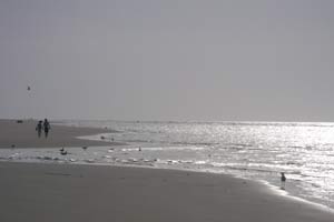 Ondergaande zon aan het strand op Goeree Overflakkee, ideaal voor een romantische wandeling